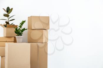 Cardboard boxes with belongings prepared for moving into new house on white background�
