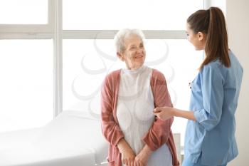 Medical worker with senior woman in nursing home 