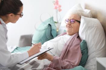 Doctor visiting senior woman in nursing home�