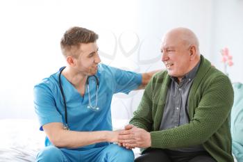 Medical worker with senior man in nursing home 