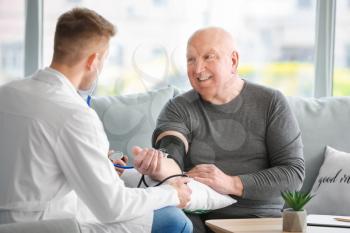 Doctor examining senior man in nursing home 