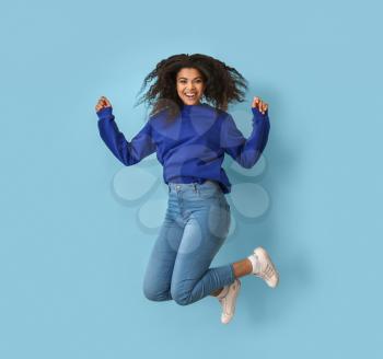 Jumping African-American woman on color background�