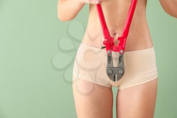 Beautiful young woman with nipping pliers on color background. Depilation concept�
