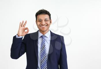 Handsome businessman showing OK on white background�