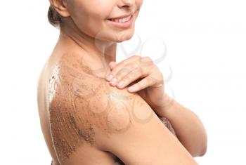 Beautiful young woman applying body scrub against white background, closeup�