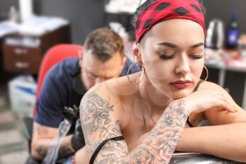 Female client getting tattoo in salon�