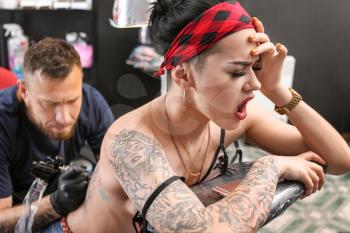 Female client getting tattoo in salon�