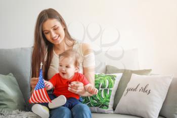 Mother and her little baby with national flag of USA at home�