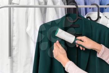Woman removing dirt from clothes at dry-cleaner's�