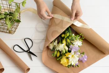Florist making beautiful bouquet in shop�