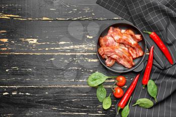 Frying pan with cooked bacon on dark table�