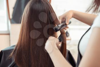 Female hairdresser working with client in salon, closeup�