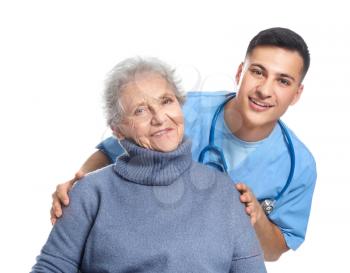 Young caregiver with senior woman on white background 