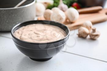 Bowl with delicious mushroom cream soup on table�
