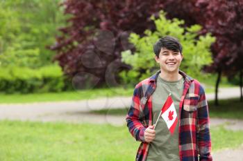 Asian student with Canadian flag outdoors�