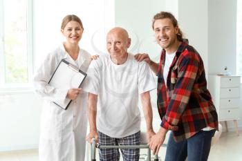 Young man visiting his elderly father in modern clinic 