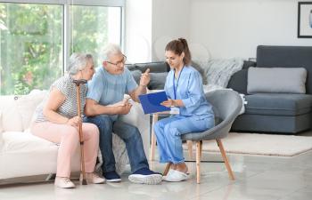 Elderly couple with caregiver in nursing home 