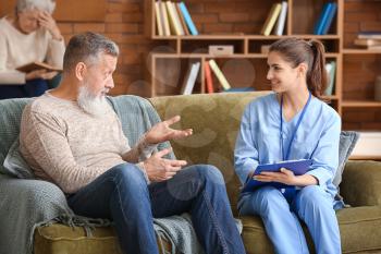 Elderly man with caregiver in nursing home 