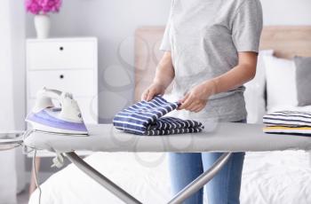Woman folding clean clothes at home�