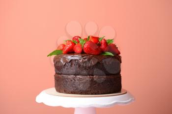 Tasty chocolate cake with strawberry on color background�