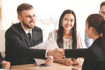 Human resources manager shaking hands with applicant after successful interview�