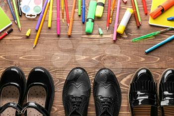Shoes and stationery on wooden background�