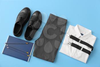 School uniform and stationery on color background�
