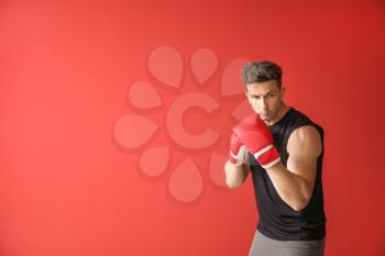 Sporty male boxer on color background�