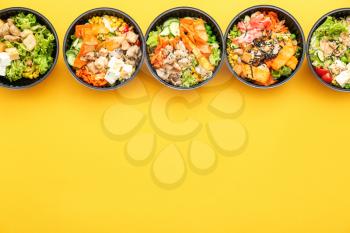 Many containers with delicious food on color background�
