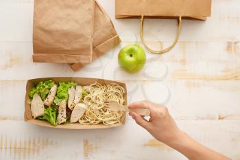 Woman eating tasty lunch ordered from food delivery service�