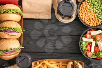 Different tasty food from delivery service on wooden background�