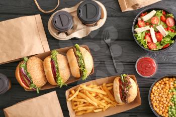 Different tasty food from delivery service on wooden background�