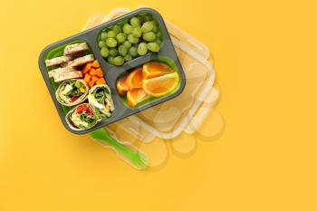 School lunch box with tasty food on color background�