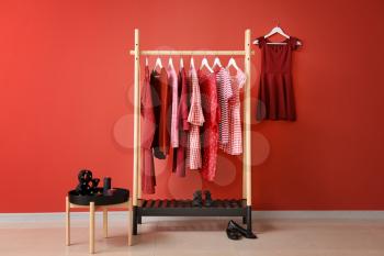 Rack with hanging clothes in interior of dressing room�