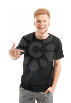 Man pointing at his t-shirt against white background�