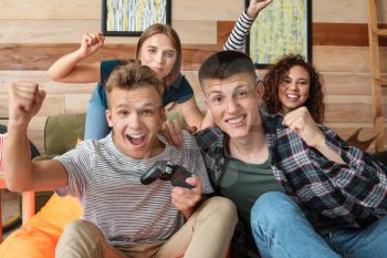 Teenagers playing video game at home�