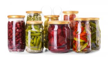Jars with different canned vegetables and legumes on white background�