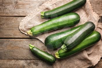 Fresh zucchini squashes on wooden background�