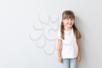Little girl in stylish t-shirt on light background�
