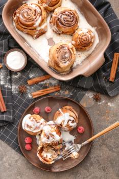 Plate with tasty cinnamon buns on table�