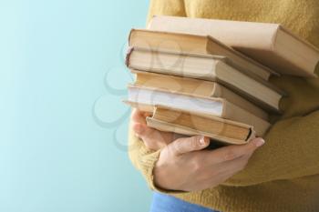 Woman with books on color background, closeup�