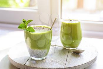Glasses of healthy smoothie on window sill�