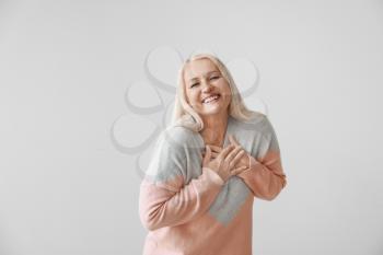Happy mature woman on grey background�