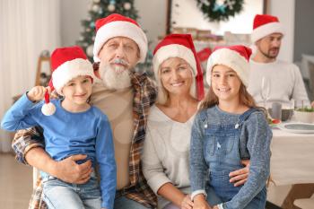 Happy grandparents with little children during Christmas party at home 