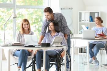Handicapped young woman with colleagues working in office�