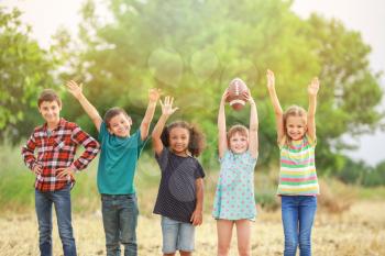 Cute little children with rugby ball outdoors�