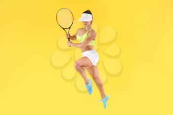 Jumping female tennis player on color background�