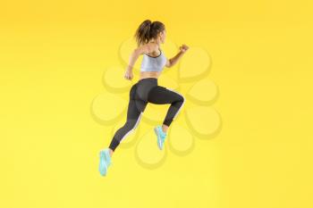 Running sporty woman on color background�