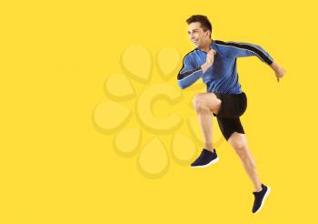 Running sporty man on color background�