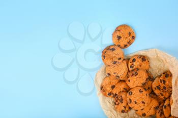 Tasty cookies with chocolate chips on color background�